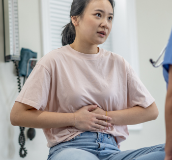 A patient indicating pain in her abdomen